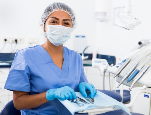 Dentist with mask sitting in dental treatment area