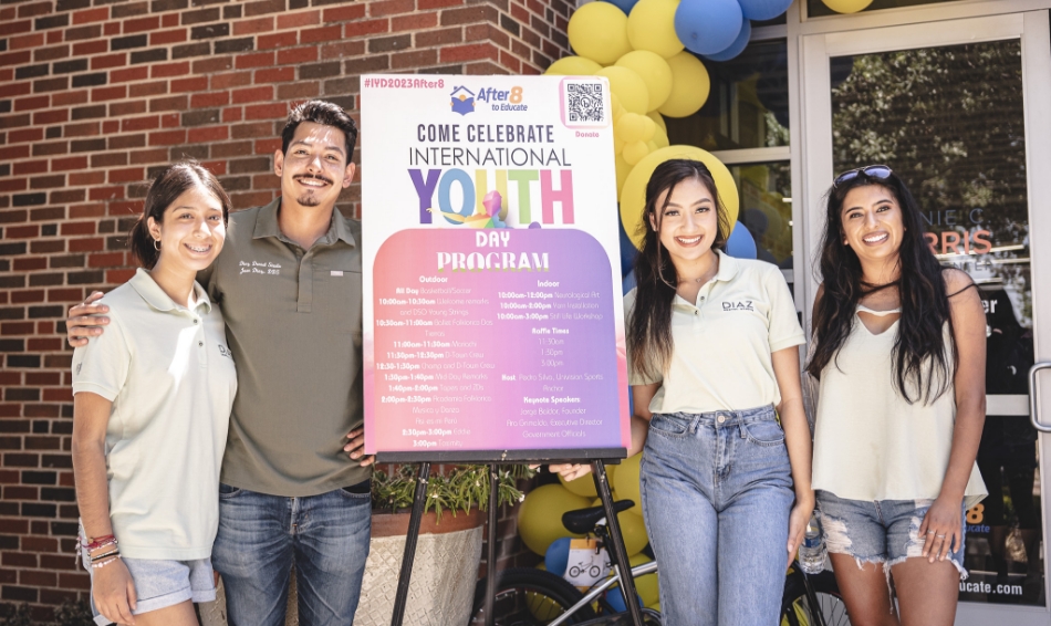 Dental team standing around poster for Youth event