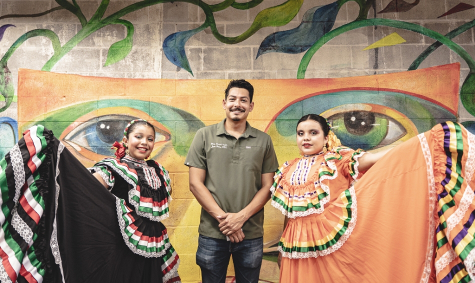 Dr Diaz with two women in front of painting with eyes