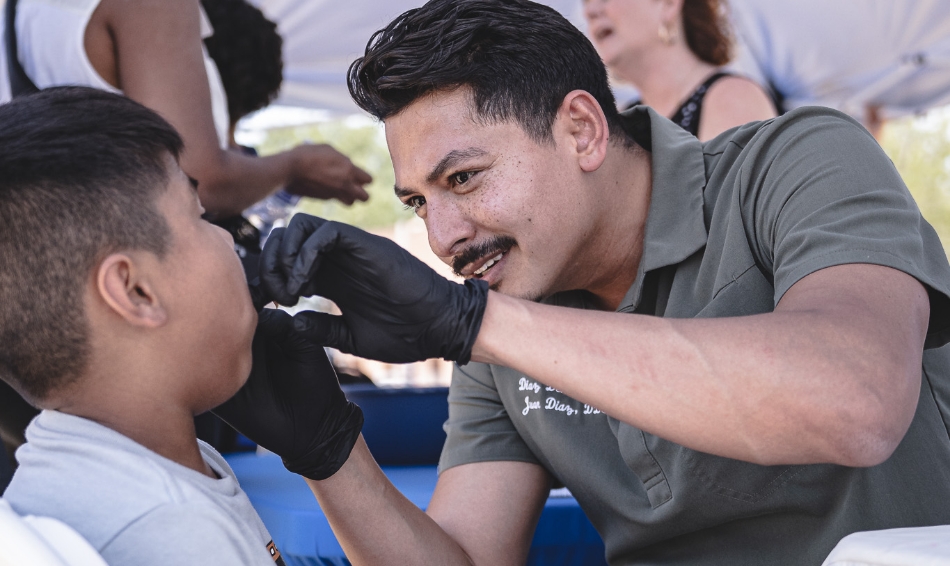 Angled shot of Dr Diaz treating a young boy