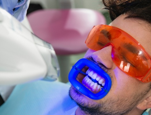 Man with protective glasses receiving teeth whitening