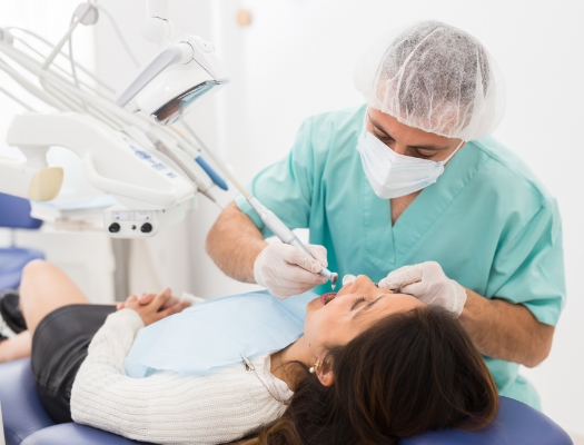 Dentist wearing mask treating a patient