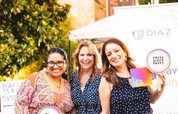 Three women standing together at pride block party