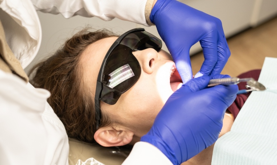 Dental patient with sunglasses having teeth examined