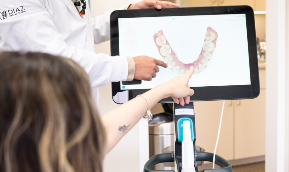 Patient pointing to digital impression of teeth on monitor