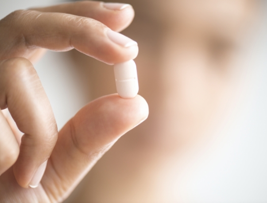 Close up of hand holding a pill